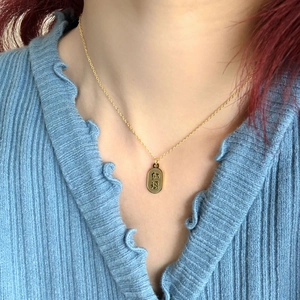 Collier doré minimaliste avec pendentif ovale Na Fu porté pour un style décontracté