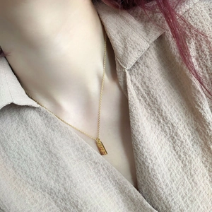 Close-up of gold-plated square pendant with Gongxi Facai engraving on necklace