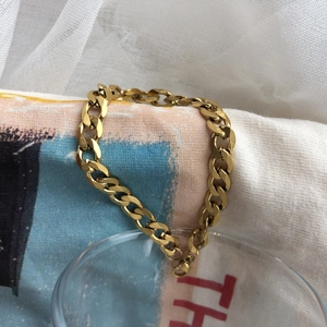 Détail du bracelet chaîne à maillons épais plaqué or avec une finition polie brillante
