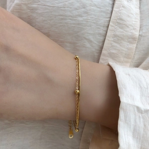 Détail du bracelet doré double épaisseur avec perles, chaîne serpent et fermoir