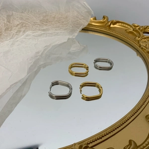 Detailed view of vintage gold and silver oval hoop earrings with textured finish