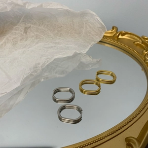 Macro view of vintage oval hoop earrings in polished gold and silver finishes