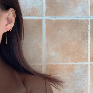 Elegant gold long tassel chain earrings with ear cuff design on a model
