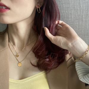 Close-up of layered gold Good Luck necklaces and matching jewelry set on model