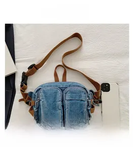 Détail du sac de poitrine en denim vintage avec sangle marron et téléphone pour comparer la taille