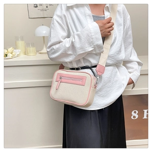 Dettaglio borsa a tracolla in tela beige e pelle rosa con tracolla larga e clip