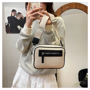Selfie allo specchio con borsa a tracolla in tela con bordo nero e cinturino