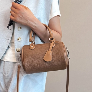 Brown lychee leather Boston cylinder bag with top handles and adjustable shoulder strap