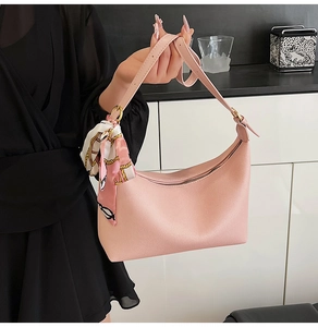 Pink crescent hobo bag with adjustable strap and decorative floral silk scarf detail