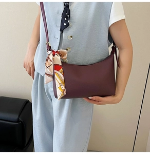 Close-up of burgundy leather hobo bag with floral silk scarf detail and fine strap