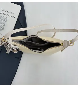 Detailed interior of beige textured shoulder bag with zipper pocket and printed silk scarf
