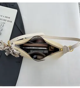 Top view of cream shoulder bag interior showing large capacity for makeup and phone
