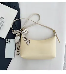 Detail of beige hobo shoulder bag with silk scarf handle and adjustable strap