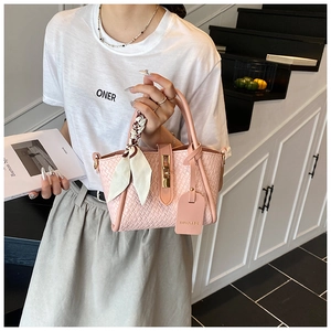 Pink woven bucket bag featuring gold buckle detail and silk scarf wrapped handle accent