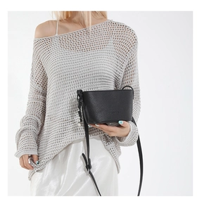 Close-up of black lychee grain texture on leather crossbody bucket bag with shoulder strap