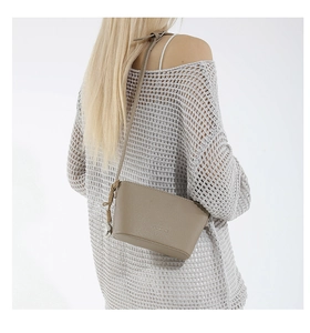 Detail view of khaki pebbled leather bucket bag with silver heart pendant and adjustable strap