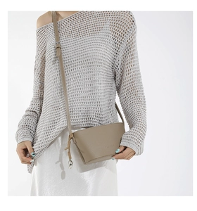 Close-up of taupe bucket bag with lychee grain leather and metal ball charm detail