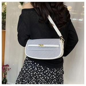Detail of blue and white geometric jacquard bag with gold twist lock and white leather strap