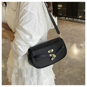 Detail of black woven texture shoulder bag with golden twist lock and semi-circular silhouette