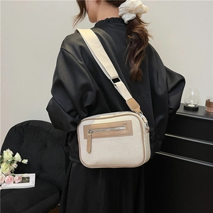 Borsa a tracolla minimalista in tela crema con finiture in pelle marrone e tracolla larga