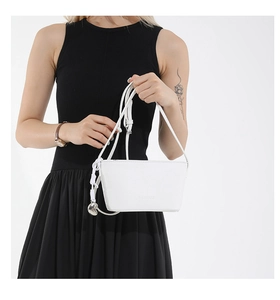 Detail of white bucket bag with litchi texture, fashion imprint and silver heart charm