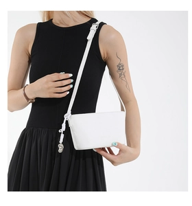Detailed shot of white lychee texture crossbody bag with silver hardware and braided knot