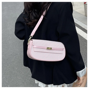 Close-up of pink leather baguette bag with woven texture detail and gold metal buckle