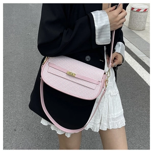 Detail of pink and white tweed texture and gold rotary lock on retro shoulder bag