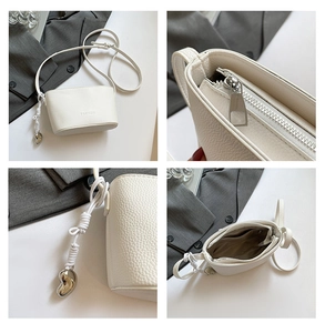 Detail shots of white lychee texture bucket bag with silver heart pendant and zipper