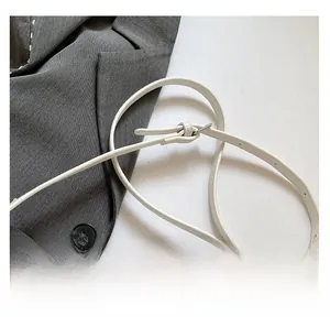 Close-up of white lychee leather adjustable shoulder strap with silver metal buckle