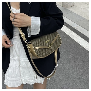 Close-up of champagne gold crossbody bag with textured pattern and metal buckle