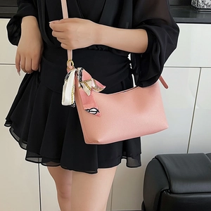 Pink faux leather crescent shoulder bag with silk scarf accessory and gold hardware detail