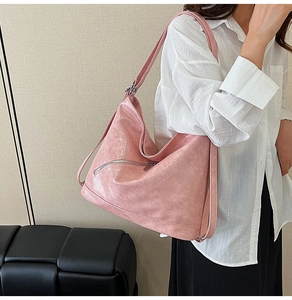 Detailed view of pink tote bag featuring crinkled texture and decorative side zippers