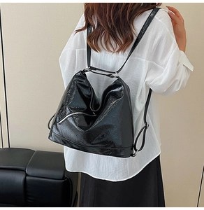 Detailed view of shiny black patent leather tote bag showing glossy pleated texture