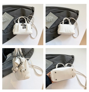 Detalle de bolso blanco en piel con cruz metálica y remaches protectores en la base