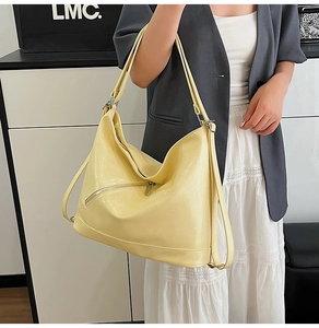 Detail of bright yellow large tote bag with zipper pocket and soft leather texture