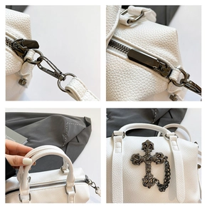 Detalle de bolso blanco de cuero granulado con cruz gótica y cadenas metálicas