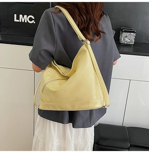 Detail of creamy yellow PU leather tote bag showing soft texture and wide shoulder strap