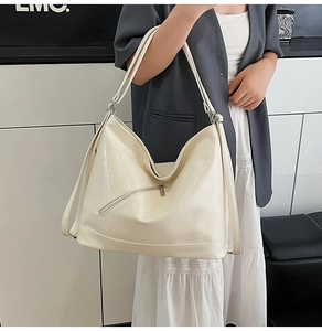 Detail of creamy white hobo tote bag featuring vintage pleated texture and diagonal zipper