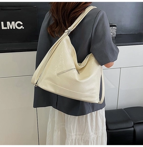 Detail view of large cream tote bag featuring a rear zipper pocket and glossy textured PU leather
