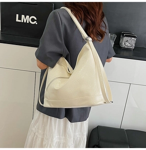 Detail of off-white hobo bag showing glossy crinkled texture and side zipper