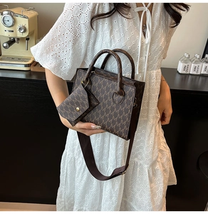 Detail of dark brown tote bag with M-pattern print and matching mini pouch on a table