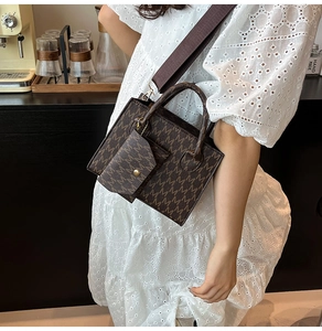 Detail of vintage brown tote bag with M-letter pattern and small matching coin purse