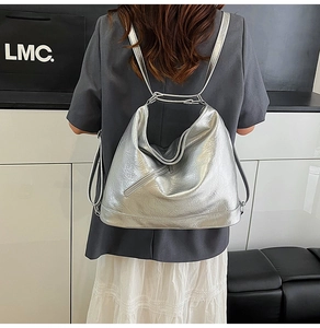 Detail view of metallic silver tote showing wrinkled leather texture and zipper details