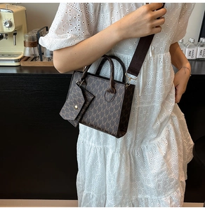 Detail of vintage brown monogram handbag with wide strap and mini pouch on model
