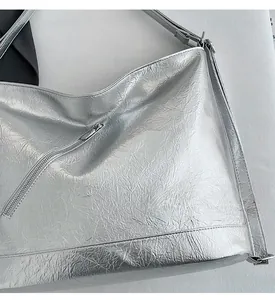 Detailed view of silver metallic bag with natural crinkle texture and diagonal zipper