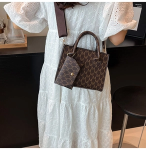 Close-up of vintage brown patterned crossbody bag with wide strap and coin purse detail