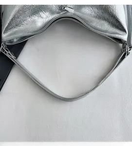 Detailed shot of comfortable shoulder strap with metallic finish and sturdy stitching