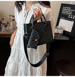 Detail of black printed tote bag set with wide shoulder strap and mini hanging pouch