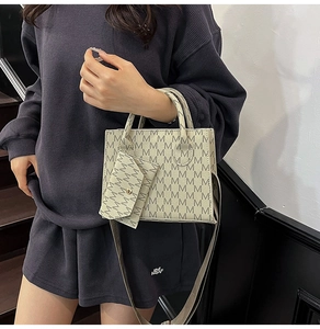 Detail of beige letter print tote bag with adjustable wide fabric shoulder strap
